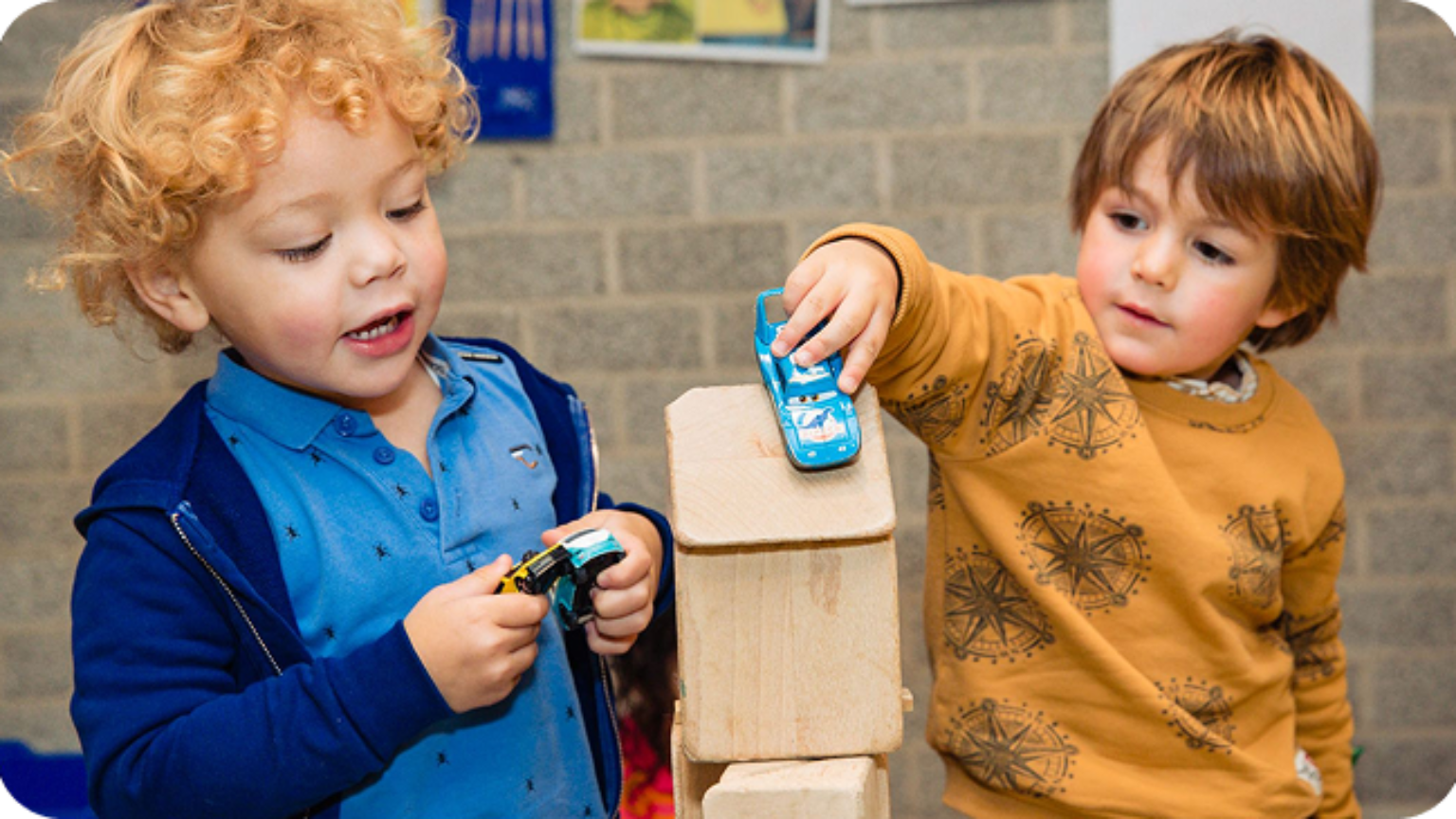 Twee jongetjes spelen met een speelgoedauto.